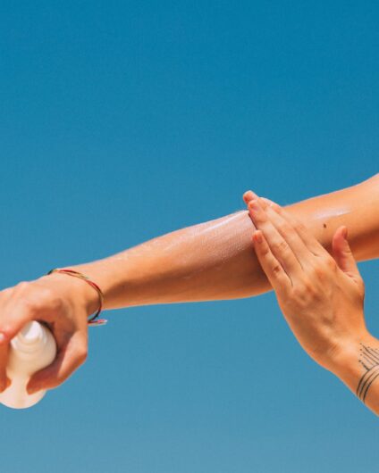 a woman applying sunscreen on arm