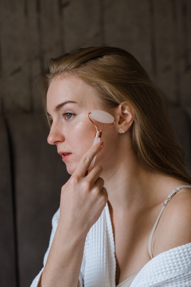 a woman massaging her face with face roller